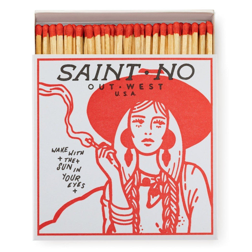 A decorative matchbox that says "Saint • No Out • West U.S.A Wake with The Sun in Your Eyes" and a girl smoking a cigarette.