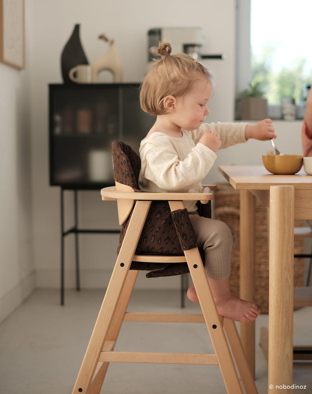 Bay sitting in wooden high chair