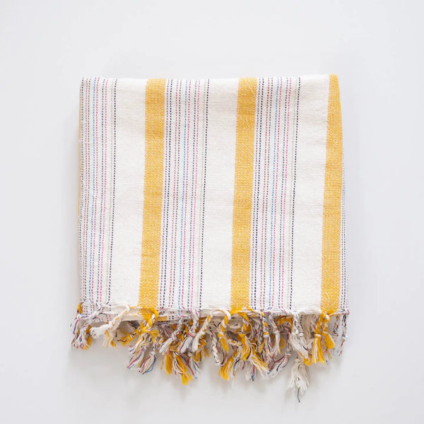 Striped towel with yellow and white stripes on a light gray background