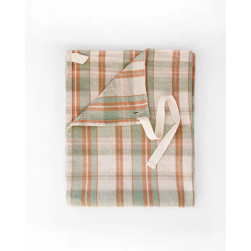A folded plaid dish towel in muted sage green, terracotta orange, and cream, featuring a matching cream drawstring, shown on a plain white background.
