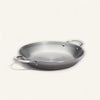 Stainless steel paella pan on a white background