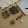 Wooden printing blocks on a textured surface with a paintbrush and canvas in the background.
