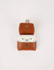 Brown leather case with white wireless earbuds on a light gray background