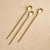 Three gold spoons on a beige background