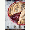 Partial view of a pie with a slice missing on a wooden surface