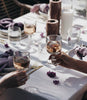 Two people toasting with glasses of wine at a dinner table.