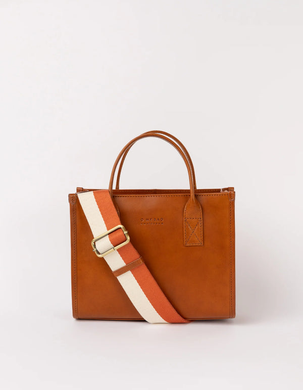 A brown leather tote bag with a structured silhouette, featuring a white and red adjustable strap and two handles.