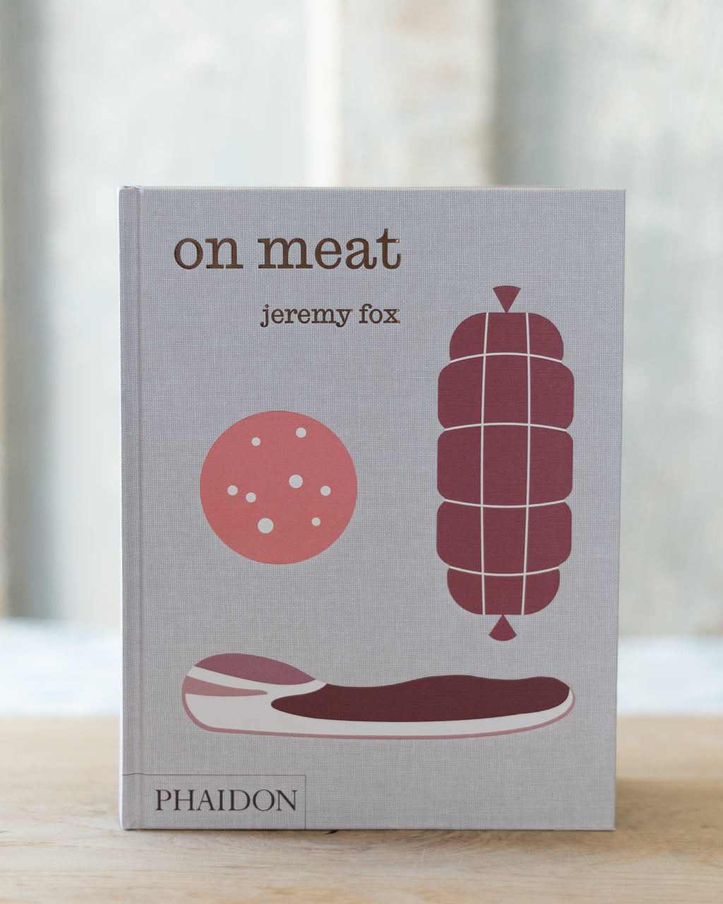 Book titled 'on meat' by Jeremy Fox with illustrations of meat products on a gray background.