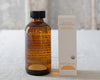 Bottle and box of Everyday Oil on a textured surface with a blurred background