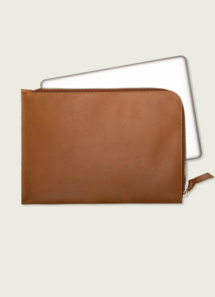 Brown leather pouch with a laptop inside on a light gray background