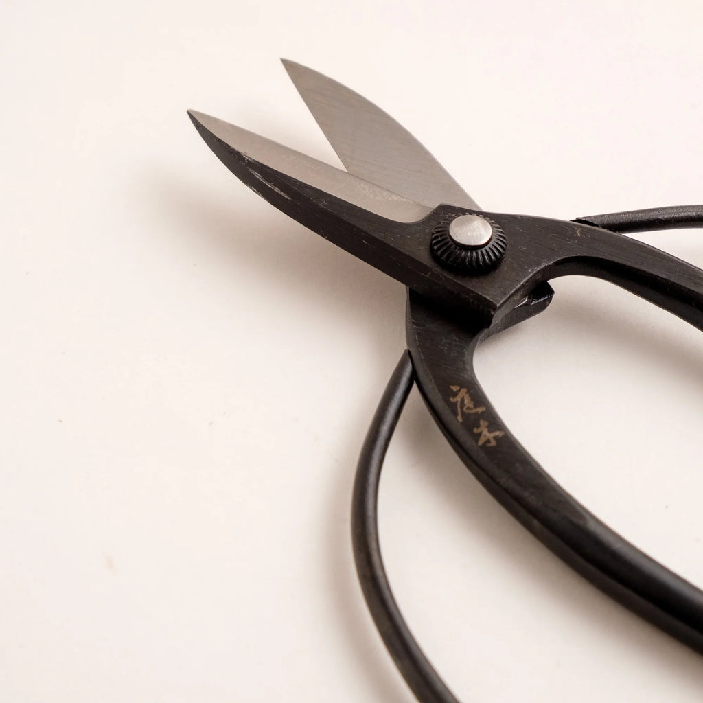 Black scissors with gold text on a white background