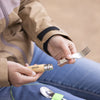 Person holding a fork and knife base with a neutral background