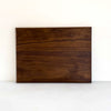 A rectangular dark brown wooden board with prominent natural wood grain patterns, displayed against a plain white background.