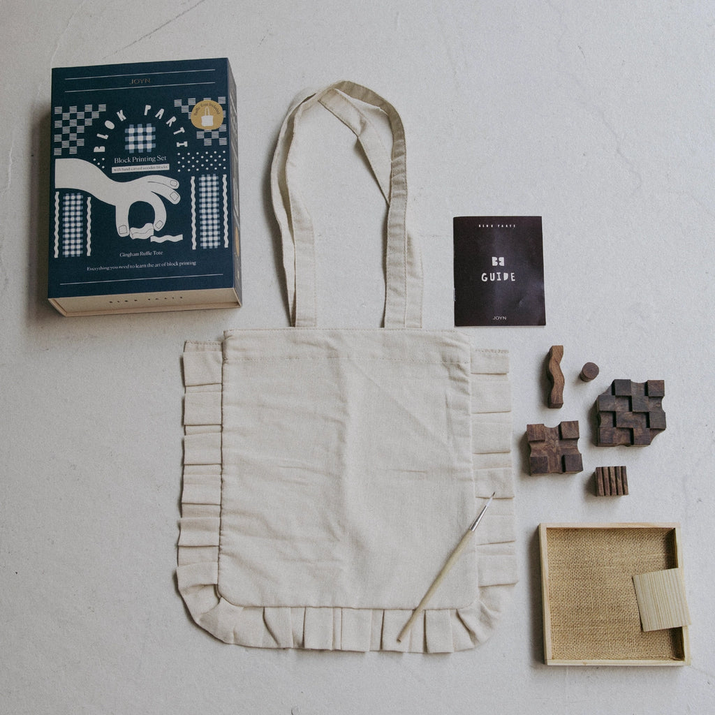 Tote bag with a book, wooden stamps, and a box on a light surface