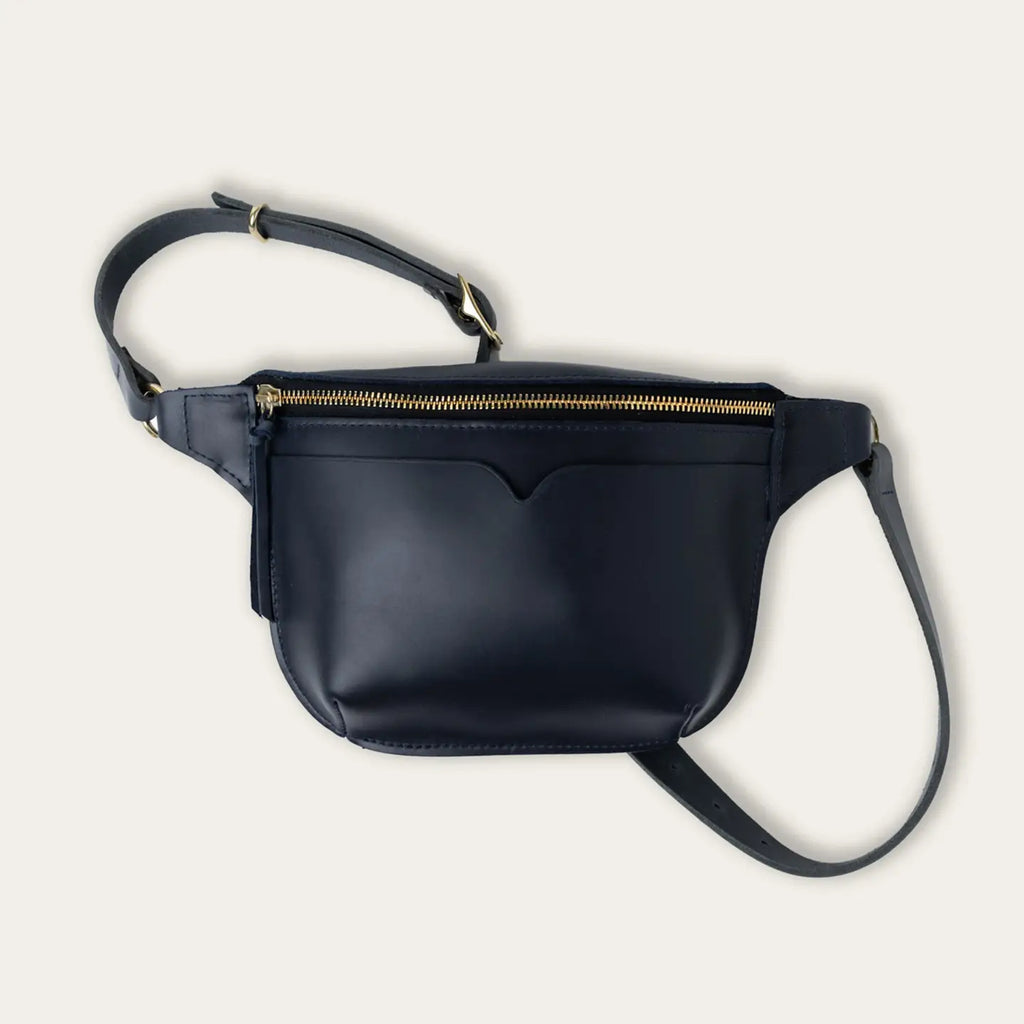Black leather crossbody bag with a strap on a light gray background
