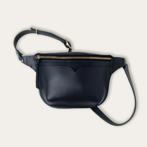 Black leather crossbody bag with a strap on a light gray background