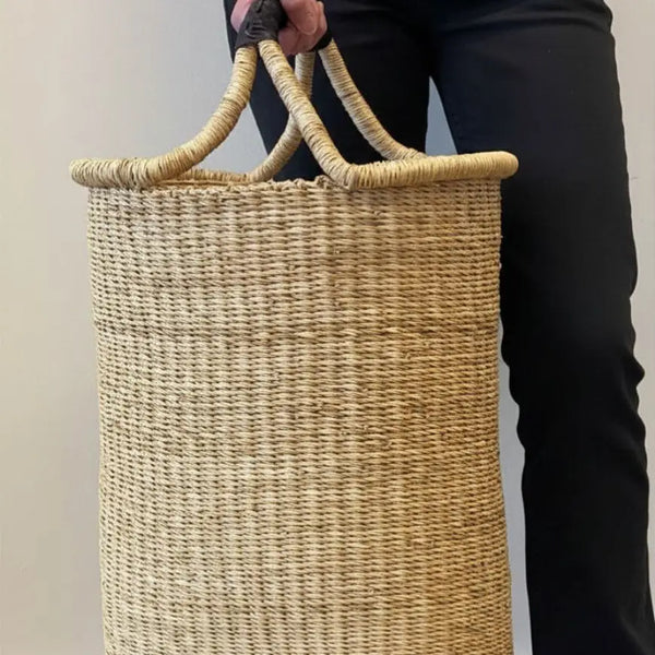 Person holding a woven basket with a plain background