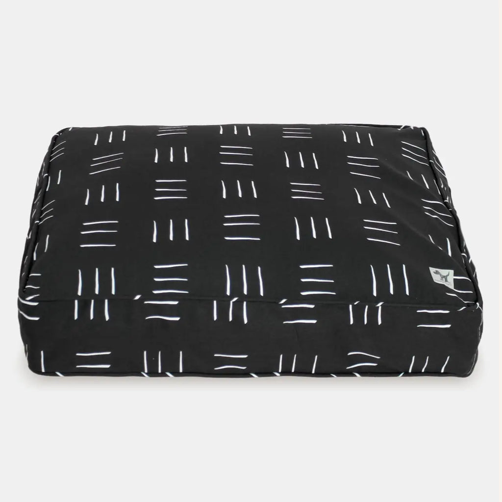 Black pet bed with white line pattern on a white background