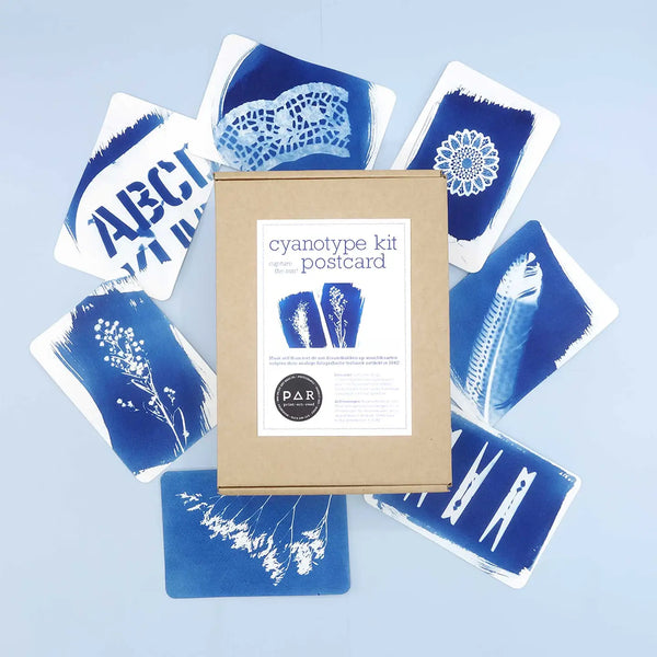 Cyanotype kit postcard set with a cardboard box on a light blue background