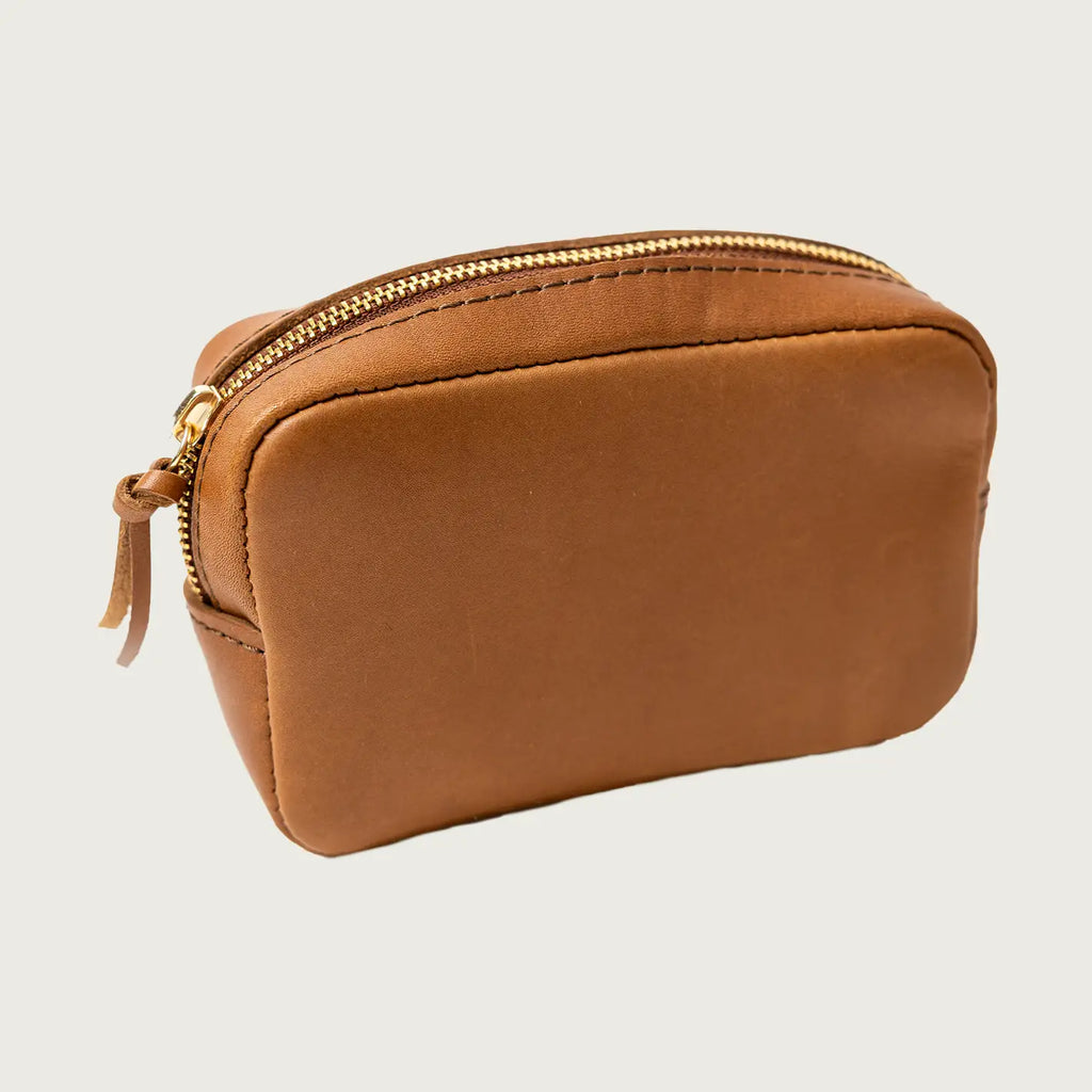 Brown leather pouch with gold zipper on a light gray background