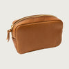 Brown leather pouch with gold zipper on a light gray background