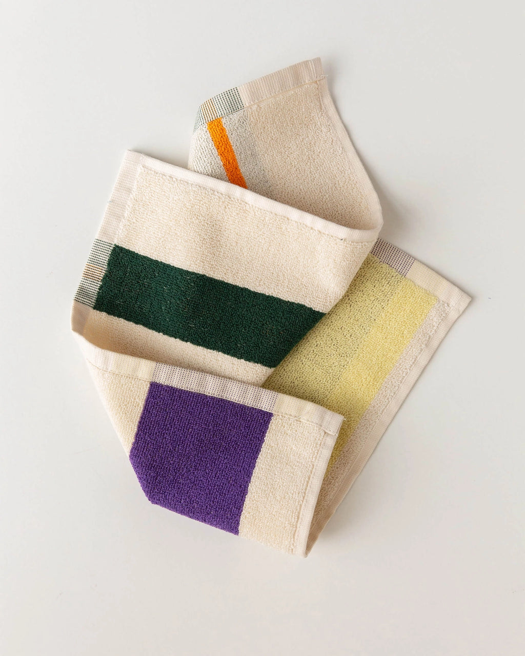 Colorful towels with geometric patterns on a light gray background
