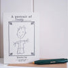 A square white card or print with the text 'A portrait of Daddy' and a simple hand-drawn sketch of a child, placed on a tan surface next to a dark green pen with gold lettering.