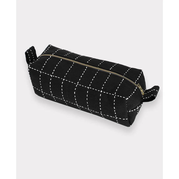 Black toiletry bag with white stitching on a light gray background
