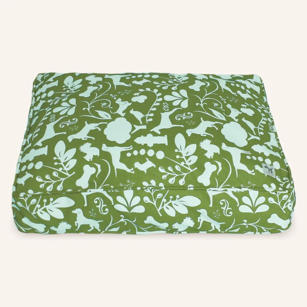 Green fabric with white floral and animal pattern on a white background