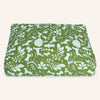Green fabric with white floral and animal pattern on a white background
