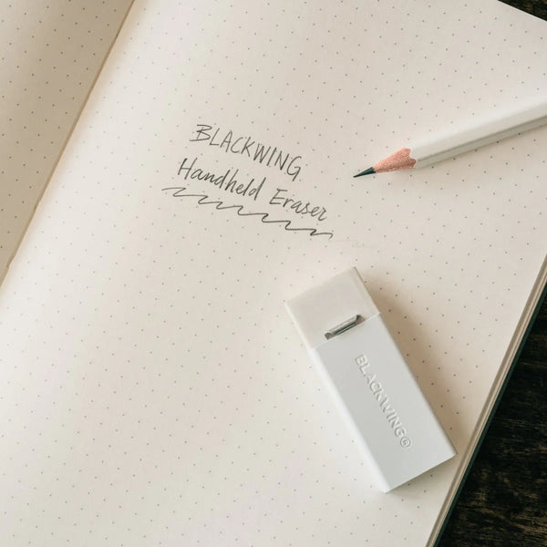 Blackwing handheld eraser on a notebook with a pencil