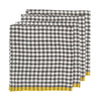 Three folded checkered napkins with a black and white gingham pattern and a yellow striped border, arranged in a stack on a white background.