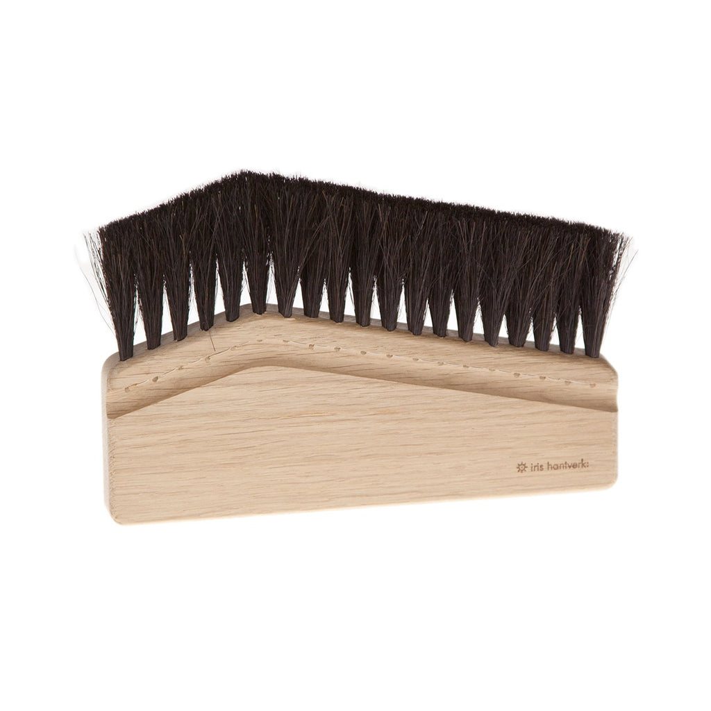 Wooden brush with black bristles on a white background