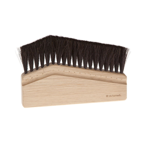 Wooden brush with black bristles on a white background