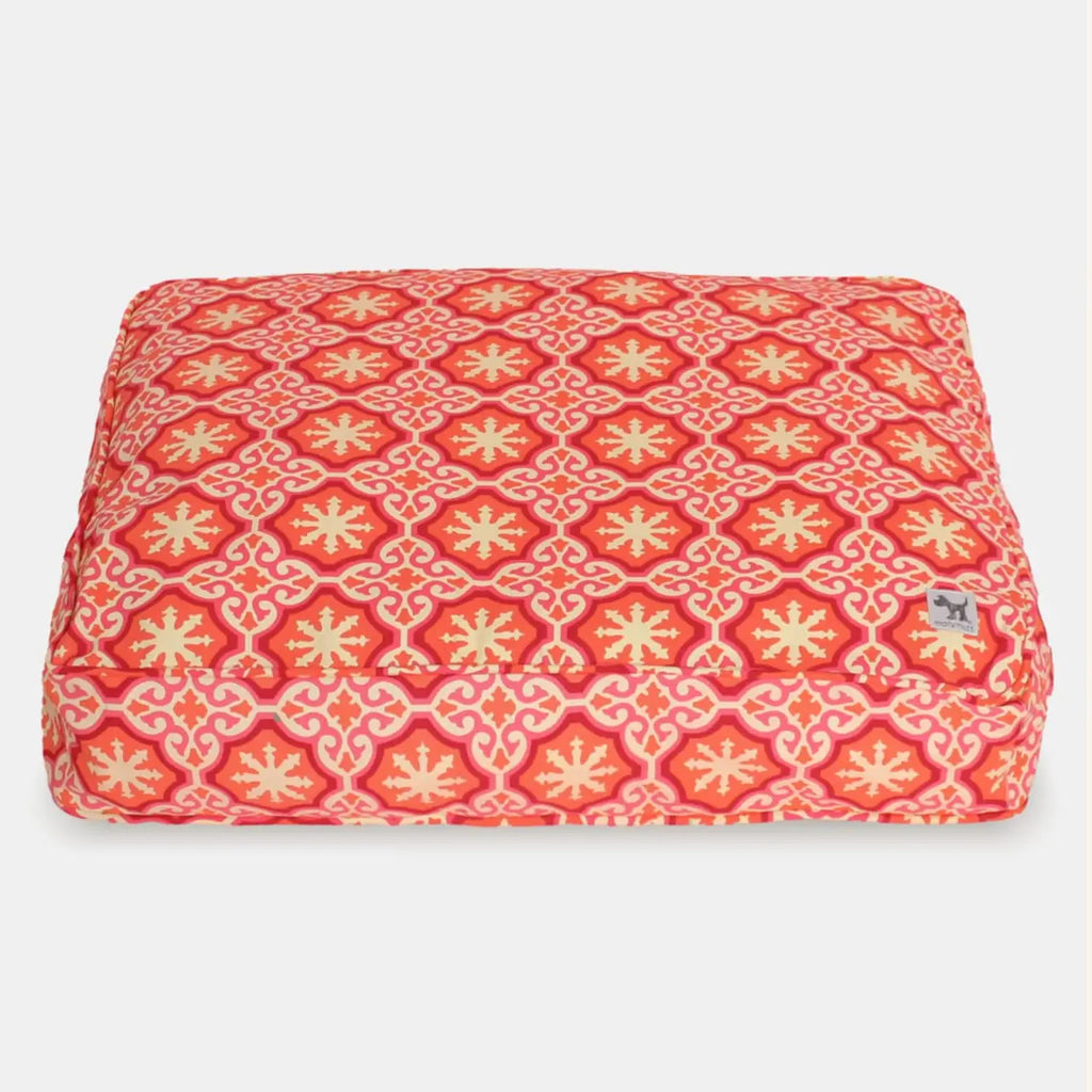 Red and yellow patterned pet bed on a white background