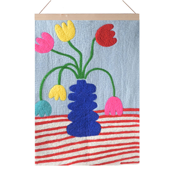 Decorative wall hanging with colorful flowers and a blue vase on a striped background