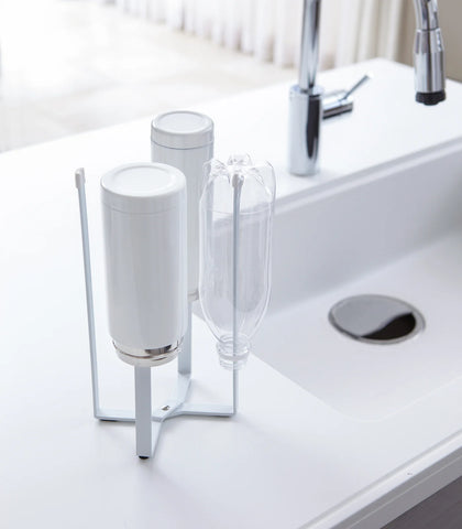 Clear glass tumblers on a stand next to a sink